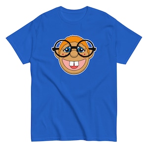 May include: A blue t-shirt with a cartoon illustration of a smiling person wearing glasses. The person has orange hair and red cheeks.