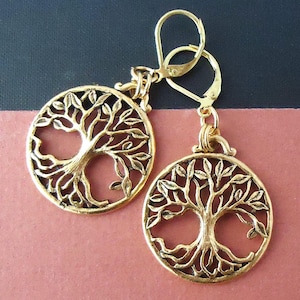 May include: Gold-toned tree of life earrings with a circular design and a hook closure.