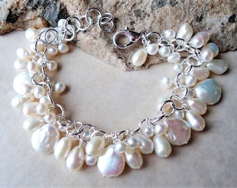 May include: A silver chain bracelet with a lobster clasp and a cluster of white freshwater pearls of varying sizes.