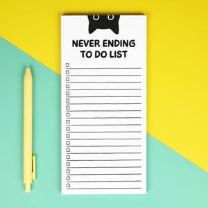 May include: A white notepad with the text "NEVER ENDING TO DO LIST" and a black cat silhouette at the top. A yellow pen is positioned to the left of the notepad. The background is split diagonally, with yellow and teal colours.