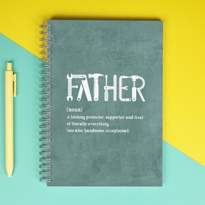 May include: A teal spiral-bound notebook with the word "FATHER" spelled out in white tools. The notebook includes the definition of father and a yellow pen on a teal and yellow background.