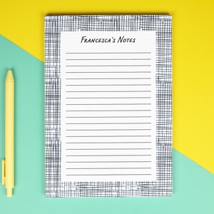 Peut inclure: Un bloc-notes ligné avec le texte "Francesca's Notes" en noir, entouré d'une bordure à motifs bleus et blancs. Un stylo jaune est positionné à gauche du bloc-notes. Le fond est divisé en diagonale en sections jaunes et turquoise.