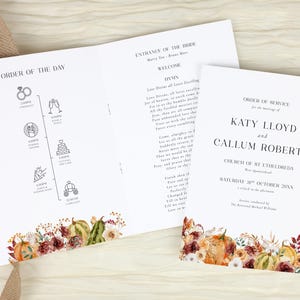 May include: A white wedding order of service booklet featuring black text and a watercolour pumpkin and floral border. The interior displays an order of the day timeline with icons, while the cover lists the names Katy Lloyd and Callum Roberts.