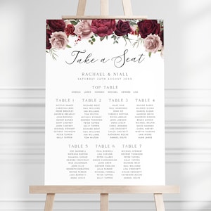 Peut inclure: Un plan de table de mariage avec un motif floral composé de roses bordeaux et blush. Le plan est intitulé "Take a Seat" et liste les noms des invités assignés à chaque table. La table d'honneur comprend les noms "Rachael & Niall" et la date "Samedi 24 août 20XX".