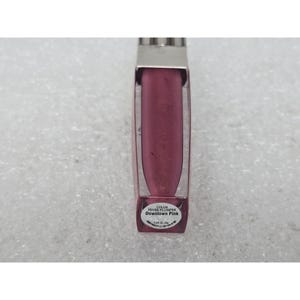 May include: A lip gloss tube with a clear plastic body and a metallic silver cap. The product inside is a deep pink shade. A white label on the base reads Color Fever Plumper Downtown Pink 0.20 oz. (6g) with additional small text below.