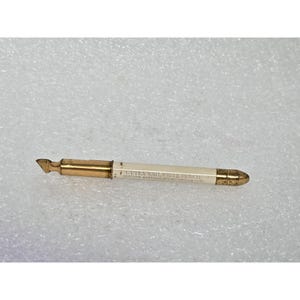 May include: A vintage Cutex Nail White Pencil, with a gold-coloured metal tip and accents. The pencil has a white body with printed text. A beauty tool.