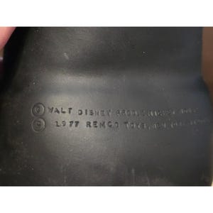 May include: A close-up of a black vintage toy with the text "WALT DISNEY PROD. MICKEY MOUSE" and "1977 REMCO TOYS, NEW YORK, N.Y. 10017". The toy is likely a collectible item.