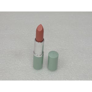 May include: A lipstick with a muted dusty rose shade and a smooth, matte-finish bullet. The casing features a cylindrical silver metal middle section and a light sage green base and matching removable cap, standing upright on a textured surface.