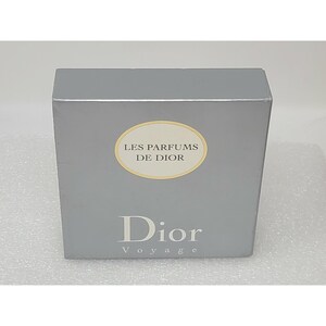 May include: A silver-colored box with the words "LES PARFUMS DE DIOR" in a gold oval and "Dior Voyage" printed in a dark gray font. The box is rectangular and appears to be a product package.