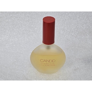 May include: A bottle of Candid Summer Light Cologne Spray. The perfume bottle is oval-shaped with a frosted glass finish. It has a red cap and the liquid inside is a light yellow color. The words "Candid Summer Light Cologne Spray" are printed on the bottle.