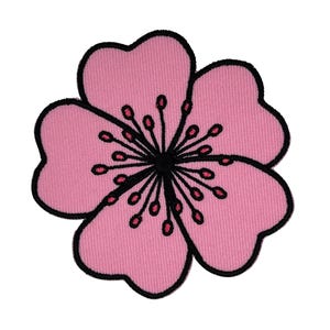 May include: A pink flower patch with a black border. The flower features four heart-shaped petals and a black centre with red details. This fabric patch is designed for sewing or ironing onto garments or accessories.