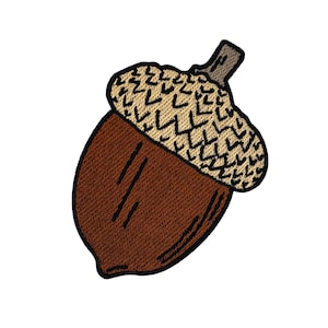 May include: Embroidered acorn patch featuring a brown nut and a tan cap with black detailing. The patch has a detailed, textured appearance, perfect for adding to clothing or accessories. The design is set against a white background.
