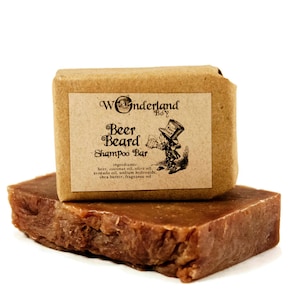May include: A brown bar of soap wrapped in brown paper with a label that reads "Wonderland Boy Beer Beard Shampoo Bar" and lists the ingredients.