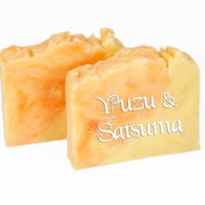 May include: Two bars of handmade soap, one orange and one yellow, with the text "Yuzu & Satsuma" printed on the yellow bar.