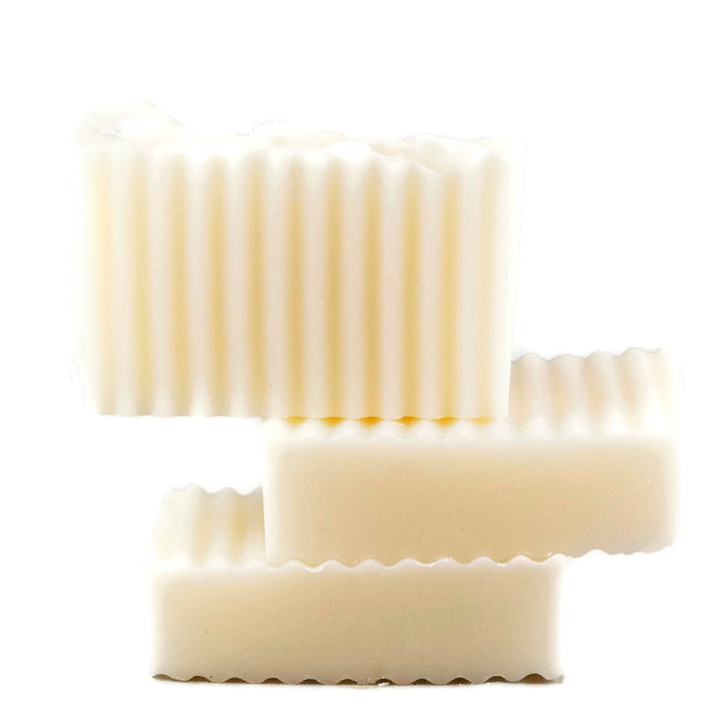 May include: Three bars of white soap stacked on top of each other. The top bar has a ridged texture.