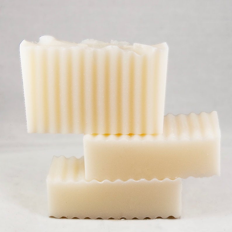 May include: Three bars of white soap stacked on top of each other. The soap has a ridged texture.