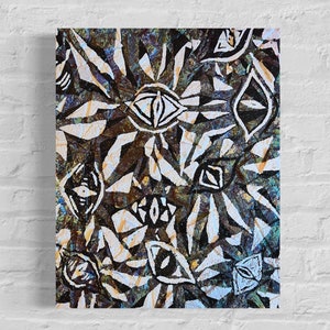 May include: Abstract art print featuring a repeating pattern of stylized eye shapes and geometric forms in white against a dark, textured background. The artwork is mounted on a canvas, creating a striking visual effect. The color palette includes shades of brown, blue, and white.