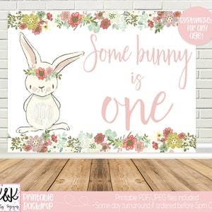 May include: Printable backdrop featuring a white bunny with a floral crown, surrounded by pink and green flowers. The text "Some bunny is one" is written in pink script.