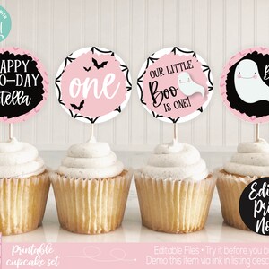 Op de afbeelding: Printbare cupcake-toppers met een roze en zwart Halloween-thema. De toppers bevatten een spook, vleermuizen en de tekst "Happy Boo-Day Stella", "Our Little Boo is One!" en "One".
