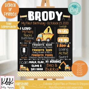May include: A black milestone sign with the name "BRODY" in white. The sign includes the text "My First Birthday" and details about the child's preferences and measurements, including 20 lbs and 29 inches. The sign has a construction theme with illustrations of trucks and construction cones.