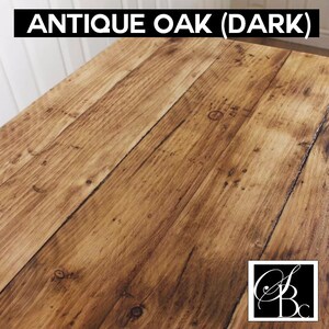 May include: Antique Oak (Dark) wood grain surface. The wood has a dark brown color with a slightly reddish hue. The surface is smooth and polished.