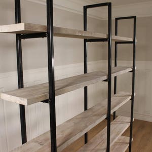 May include: A tall, industrial-style bookshelf with five shelves made of reclaimed wood. The shelves are supported by black metal frames.