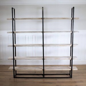 May include: A black metal bookshelf with five wooden shelves. The shelves are a light wood color with a whitewashed finish.