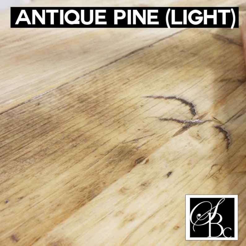 May include: Close-up of a light wood surface with a knot in the wood. The wood has a light brown color with a slightly reddish hue. The surface is smooth and has a slight sheen. The wood is called "Antique Pine (Light)".