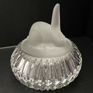 May include: A clear glass lidded dish with a frosted glass rabbit figurine on top. The dish has a fluted design.
