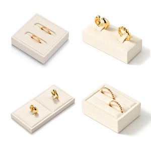 May include: Four images showcasing gold rings displayed on off-white ring holders. The rings vary in design, including bands, twisted styles, and rings with small embellishments. The presentation highlights the jewelry's details.