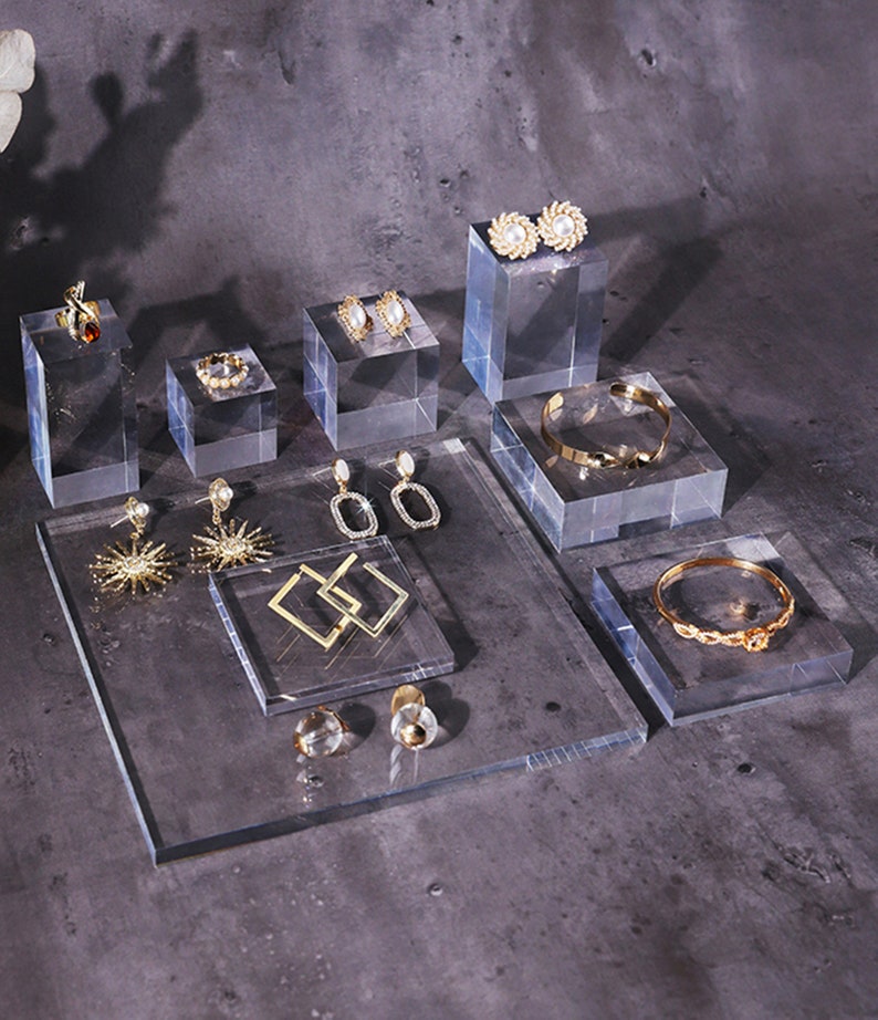 May include: A set of clear acrylic display stands for jewelry. The stands are in various sizes and shapes, and they are perfect for showcasing earrings, rings, bracelets, and necklaces. The stands are made of high-quality acrylic, which is durable and easy to clean.