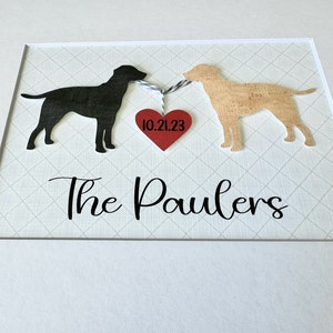 May include: A framed print with two black and brown dog silhouettes holding a red heart with the date 10.21.23. The text "The Paulers" is below the dogs.