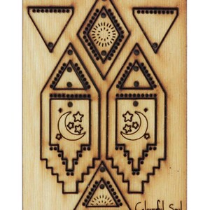 Könnte beinhalten: Ein Holzausschnitt mit einem geometrischen Design, das eine Sichelmond und Sterne zeigt. Das Design wird zweimal wiederholt und ist von einem Rand aus Dreiecken und Rauten umgeben. Die Worte "Colourful Soul" sind unten in Kursivschrift auf dem Ausschnitt geschrieben.