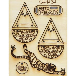 Könnte beinhalten: Ausgeschnittenes Holzdesign mit einem Tiger, zwei Dreiecken und zwei Halbkreisen mit Leopardenmuster. Das Design enthält auch den Text "Colorful Soul" und "ANTI FEAR".