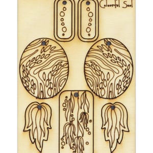 Könnte beinhalten: Lasergeschnittene Holzohrringe mit einem verspielten Design mit abstrakten Formen und Wirbeln. Die Ohrringe sind mit "Colorful Soul" beschriftet.