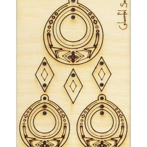 Könnte beinhalten: Eine Holzplatte mit einem Laser-geschnittenen Design zum Herstellen von Ohrringen. Das Design umfasst zwei große, runde Ohrringe mit geometrischen Mustern und drei kleinere, rautenförmige Ohrringe. Der Text "Colorful Soul" ist in der oberen rechten Ecke gedruckt.