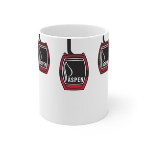 May include: White ceramic mug with a red and black graphic of a gondola with the word "ASPEN" printed on it. The gondola graphic is repeated on the mug.