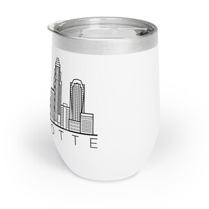 May include: White stainless steel tumbler with a black outline of the Charlotte, North Carolina skyline and the word "LOTTE" printed below.