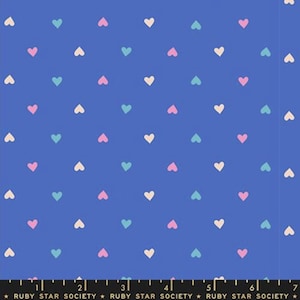 May include: A blue fabric with a repeating pattern of small hearts in pastel colors: pink, light blue, and off-white. The fabric has a grid-like arrangement of hearts, creating a playful and cheerful design. The text "RUBY STAR SOCIETY" is at the bottom.