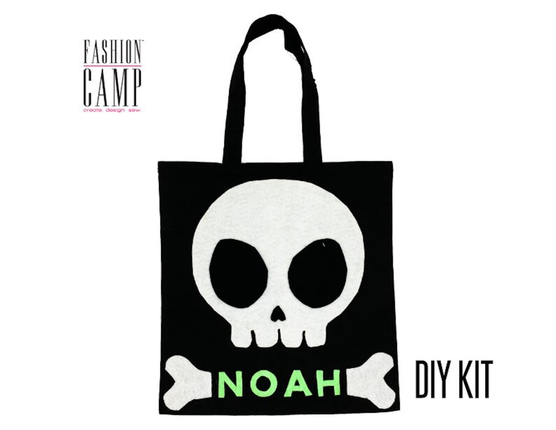 Peut inclure: Kit de bricolage pour un sac fourre-tout en feutre noir avec un motif de cr&acirc;ne et d'os blancs. Le sac porte le nom "NOAH" en feutre vert et les mots "DIY KIT" en blanc.
