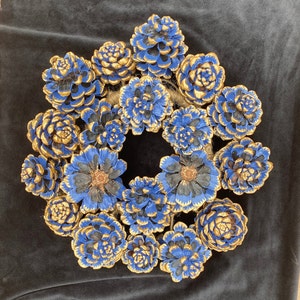 Corona de cono de pino de Pinus Pinea en color azul intenso y borde perfilado en oro. Brush painted natural pine cones wreath in blue .
