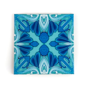 Peut inclure: Un carreau de céramique bleu et vert avec un motif géométrique. Le carreau a un design en spirale avec une étoile centrale.
