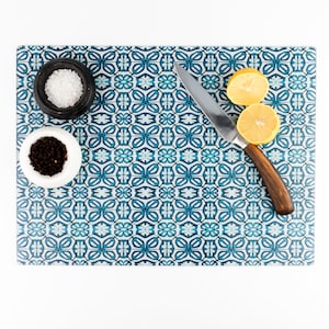 May include: A blue and white patterned cutting board with a knife, two small bowls of salt and pepper, and two lemon halves.