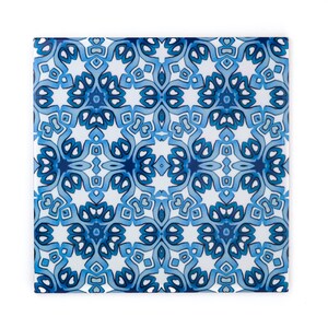 Può includere: Piastrella quadrata in ceramica con un motivo ripetuto di forme floreali e geometriche blu e bianche. Il design presenta varie tonalità di blu, creando un aspetto simmetrico e decorativo. La piastrella è probabilmente per l'arredamento della casa o progetti artigianali.