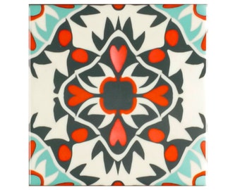 May include: A square tile with a geometric pattern in shades of teal, white, gray, and red. The pattern features a central motif of stylized flowers and hearts.