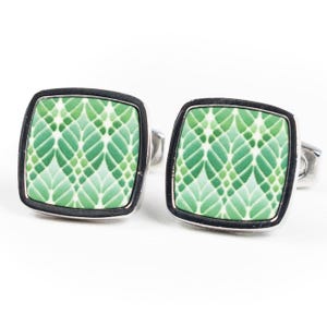 May include: A pair of silver cufflinks with a green geometric pattern.