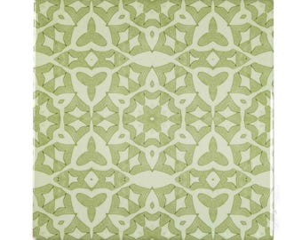 May include: A green and white ceramic tile with a repeating geometric pattern. The pattern is made up of interlocking shapes, including stars, diamonds, and triangles.