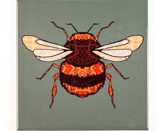 May include: A ceramic tile with a colorful, patterned bumble bee design. The bee is orange, red, and black with intricate patterns on its body and wings. The background is a muted green.