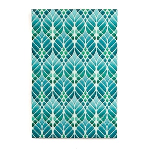 Op de afbeelding: Een teal en groen geometrisch patroon met een herhalend bladontwerp. Het patroon is op een witte achtergrond.