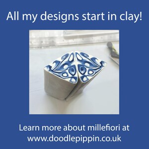 May include: Two triangular clay canes featuring a blue and white swirling pattern. The text reads: All my designs start in clay! Learn more about millefiori at www.doodlepippin.co.uk. A metal ruler is visible in the background behind the clay pieces.